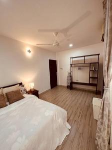 1 dormitorio con 1 cama blanca grande y suelo de madera en The Cozier, the Better at Oysterbay, en Dar es Salaam