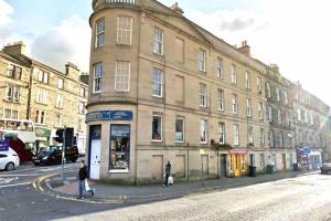 un edificio en la esquina de una calle con gente cruzando la calle en Stylish, Central And Cosy 1BD Nr Canongate, en Edimburgo