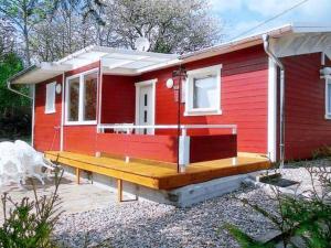 una casita roja pequeña con terraza de madera en Ferienhaus Beerberg en Suhl