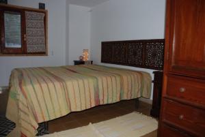 a bedroom with a bed and a dresser at sull'arco dell'elefante in Pantelleria