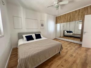1 dormitorio con 1 cama y ventilador de techo en The Symphony of the Breeze en Netanya
