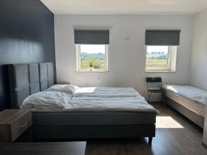 a bedroom with a bed and two windows at Kwatery Smroków in Smroków
