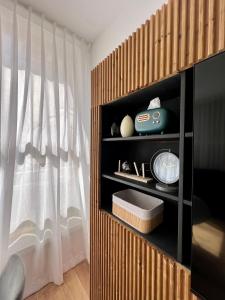 a room with a curtain and a shelf with a clock at The Symphony of the Breeze in Netanya