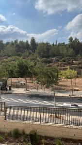 eine Straße mit einem Zaun neben einer Straße mit Bäumen in der Unterkunft מורדות עין כרם in ‘En Kerem