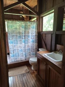 a bathroom with a toilet and a sink at Casa Heliconia - spacious, big garden, close to the beach in Puerto Viejo