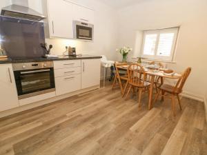 cocina y comedor con mesa y sillas en The Apartment Stow-on-the-Wold en Stow on the Wold