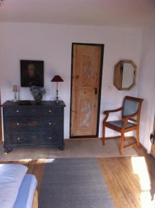 um quarto com uma cómoda, uma cadeira e uma porta em Bel Etage - Historisches Refugium in der Altstadt von Ebersberg em Ebersberg