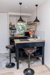 a kitchen with two bar stools and a kitchen island at Studio design rénové/ Berges du Rhone in Lyon