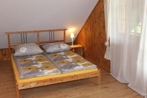 a bed in a room with a wooden floor at Domek Wypoczynkowy OSTOJA in Baligród