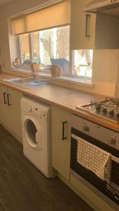 a kitchen with a washing machine and a sink at Alice - spacious 3 bedroom house contractor accommodation in Sunderland