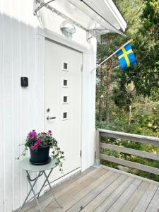 a white door with a flag on a porch at Lilla huset Bed & Breakfast - gästhus 1-3 personer och egen parkering in Örebro