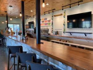 a bar in a restaurant with a wooden counter and chairs at BeeWeaver Luxury Glamping - All That Glitters in Navasota