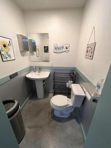 a bathroom with a toilet and a sink at BeeWeaver Luxury Glamping - All That Glitters in Navasota