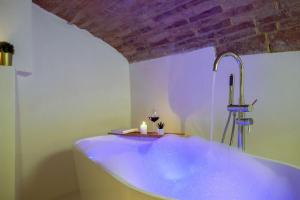 a bathroom with a tub with a candle and a sink at Medieval flat with whirlpool bath in Perugia