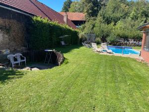 a yard with chairs and a swimming pool at Apartmán Beruška in Křelovice