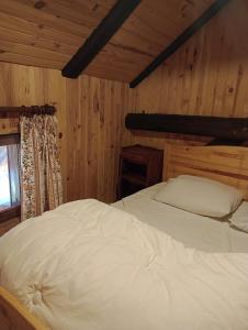 um quarto com uma cama num quarto com paredes de madeira em Chalet les Chardons em Celliers