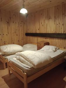 um quarto com 2 camas num quarto com paredes de madeira em Chalet les Chardons em Celliers