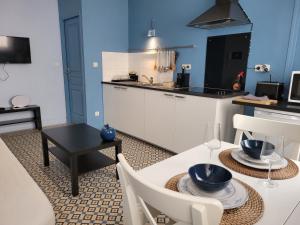 a kitchen and dining room with a table and chairs at Apt 2 du Temple HyperCentre & Parking in Cambrai