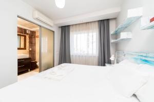 een slaapkamer met een wit bed en een spiegel bij Flat with Pool Balcony 7 min to Konyaalti Beach in Antalya