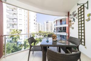 een balkon met een tafel en stoelen en uitzicht op de gebouwen bij Flat with Pool Balcony 7 min to Konyaalti Beach in Antalya