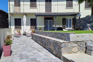 dom z kamienną ścianą i patio w obiekcie Casa Ducale Como Lake View w mieście Mandello del Lario