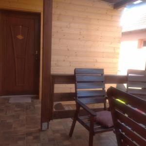 eine Veranda mit einer Tür, 2 Stühlen und einer Tür in der Unterkunft Kaptárkő Apartmanház in Demjén