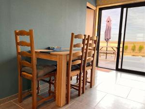 mesa de comedor y sillas con vistas a un patio en les gîtes du péré, en Soubise