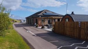 a building with a fence next to a house at Marina Bay Pods in Aberdeen