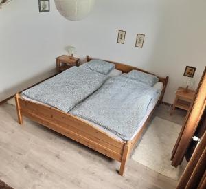 ein Schlafzimmer mit einem Holzbett mit zwei Nachttischen in der Unterkunft Appartement de vacances à Torgon in Vionnaz