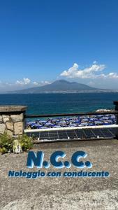 ein Schild für einen Strand mit dem Meer im Hintergrund in der Unterkunft Chiaro di luna in Castellammare di Stabia