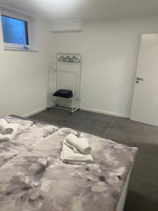 a white room with a bed with towels on it at L&L in Korb