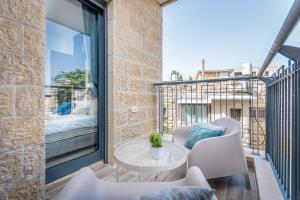 balcón con mesa, sillas y cama en Luxury 2BR with Nice View - Next King David Hotel, en Jerusalén