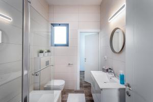 bagno bianco con lavandino e specchio. di Luxury 2BR with Nice View - Next King David Hotel a Gerusalemme Altre 13 foto