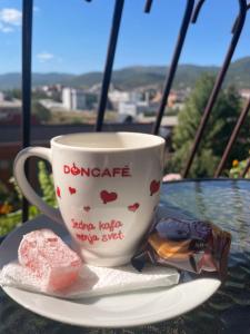 una tazza di caffè e un pezzo di cibo su un piatto di Michel FREE PARKING a Vranje