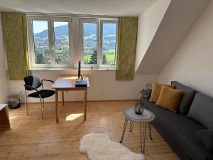 uma sala de estar com um sofá e uma mesa em Panoramablick Scheifling em Lind bei Scheifling