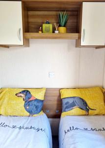 a bedroom with two beds with a dog on the pillow at Eden Breaks, Mallard Lake in Cirencester