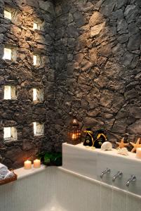 a bathroom with a bath tub with a stone wall at The Villas at Bahia del Duque in Adeje