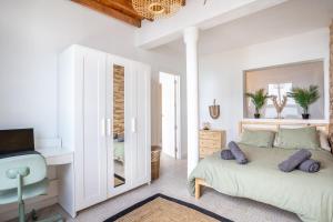 una camera da letto bianca con un letto e uno specchio di Calima de Jover a La Laguna