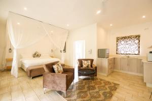 a bedroom with a bed and a table and chairs at Pristine deluxe room with kitchen and pool - 2147 in Victoria Falls