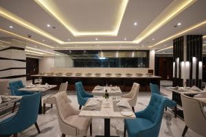 a restaurant with white tables and blue chairs at The Royal Bihar in Patna