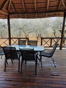 a picnic table and chairs on a wooden deck at Habibi Holiday Home in Marloth Park