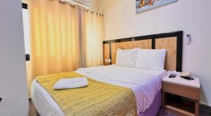 a bedroom with a large bed with a wooden headboard at Sharjah Plaza Hotel in Sharjah