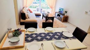 a kitchen and living room with a table and chairs at IPOH All Suite Resort, Jalan Haven, Persiaran Lembah Perpaduan, Ipoh Perak in Ipoh