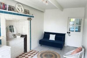 uma sala de estar com uma cadeira azul e um espelho em Maison bigoudène à 5 minutes de Pors Carn em Penmarcʼh