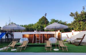 a group of chairs and umbrellas and a playground at Guest House - Heaven in Byala