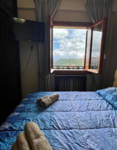 una camera con un letto blu e una finestra di Residence Horizonte Roccaraso a Roccaraso