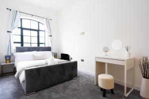 a white bedroom with a bed and a desk and a desk at Stunning Townhouse with Pool Table in Birmingham