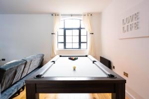 ein Wohnzimmer mit einem Billardtisch vor einem Fenster in der Unterkunft Stunning Townhouse with Pool Table in Birmingham