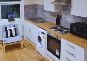 a kitchen with a washing machine and a microwave at Modern 2 Bedroom Apartment in Peckham London in London