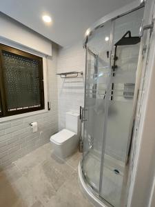 a bathroom with a toilet and a glass shower at C2 Exclusiva zona Madrid in Madrid